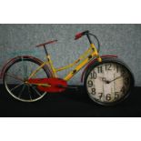 A clock in the form of a bicycle. In a distressed finish. H.33 W.55cm.