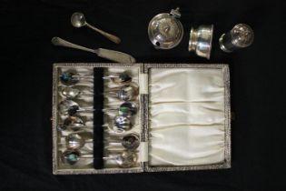 A mixed collection of silver plate including a set of scalloped spoons, a sugar pot, and salt