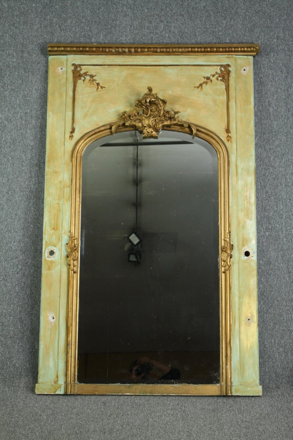 A 19th century French painted panel with giltwood and gesso pier glass with Rococo cresting above