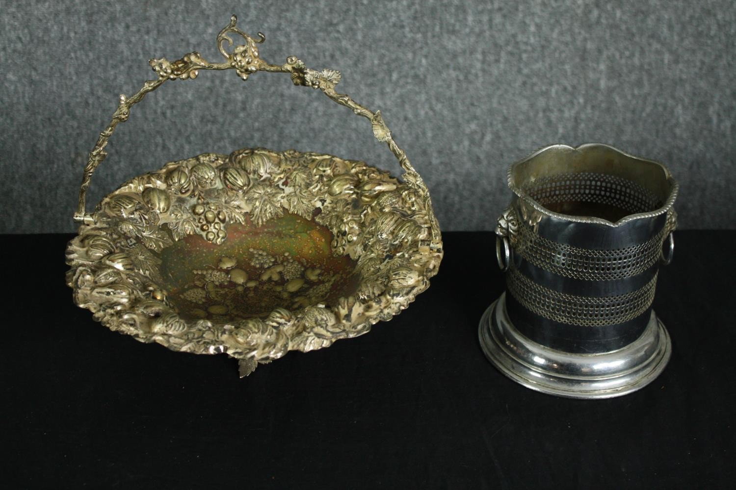 A silver plated wine bottle coaster with twin lion head handles along with a silver plated