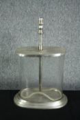 A glass table lamp. With an extending stem. Chromed metal and glass. With a loose rubber seal.
