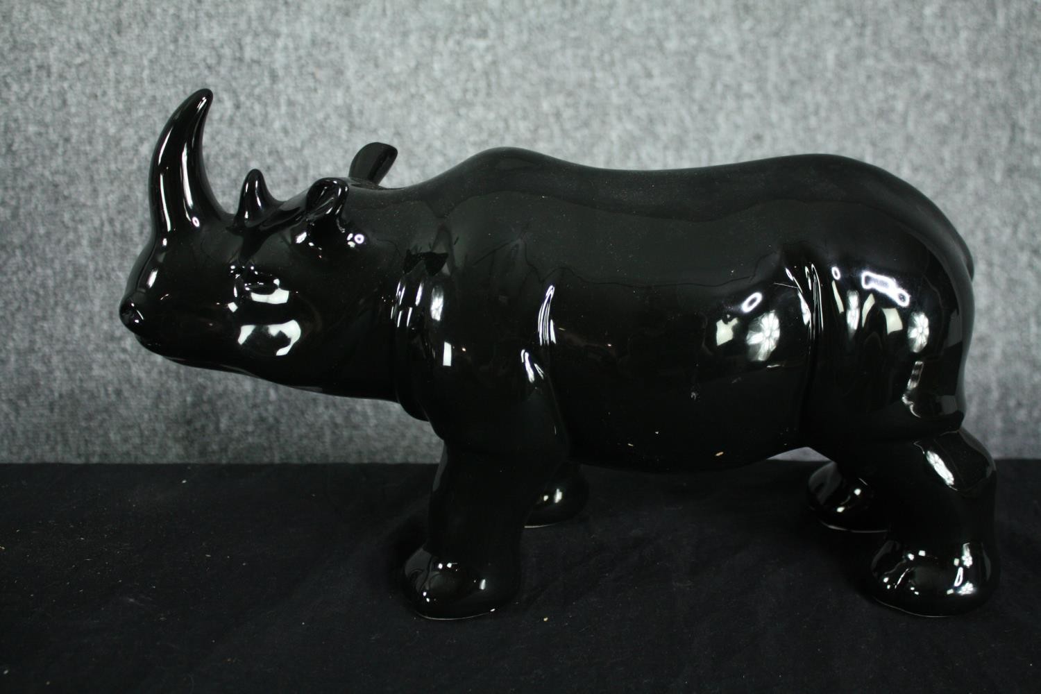 A pair of ceramic rhino figures. In a black painted glaze. H.23 W.40cm. (each) - Image 2 of 3
