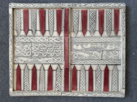 A vintage backgammon board in resin on a grip base, moulded to resemble bone and inlay. Decorated