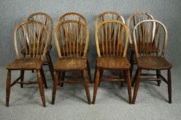 A set of eight C.1900 elm seated stick back kitchen chairs.