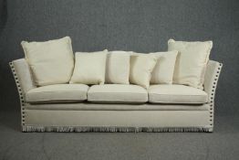 A Knole sofa, fully re-upholstered and covered with a matching set of cushions. H.80 W.250 D.75cm.