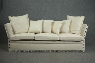 A Knole sofa, fully re-upholstered and covered with a matching set of cushions. H.80 W.250 D.75cm.