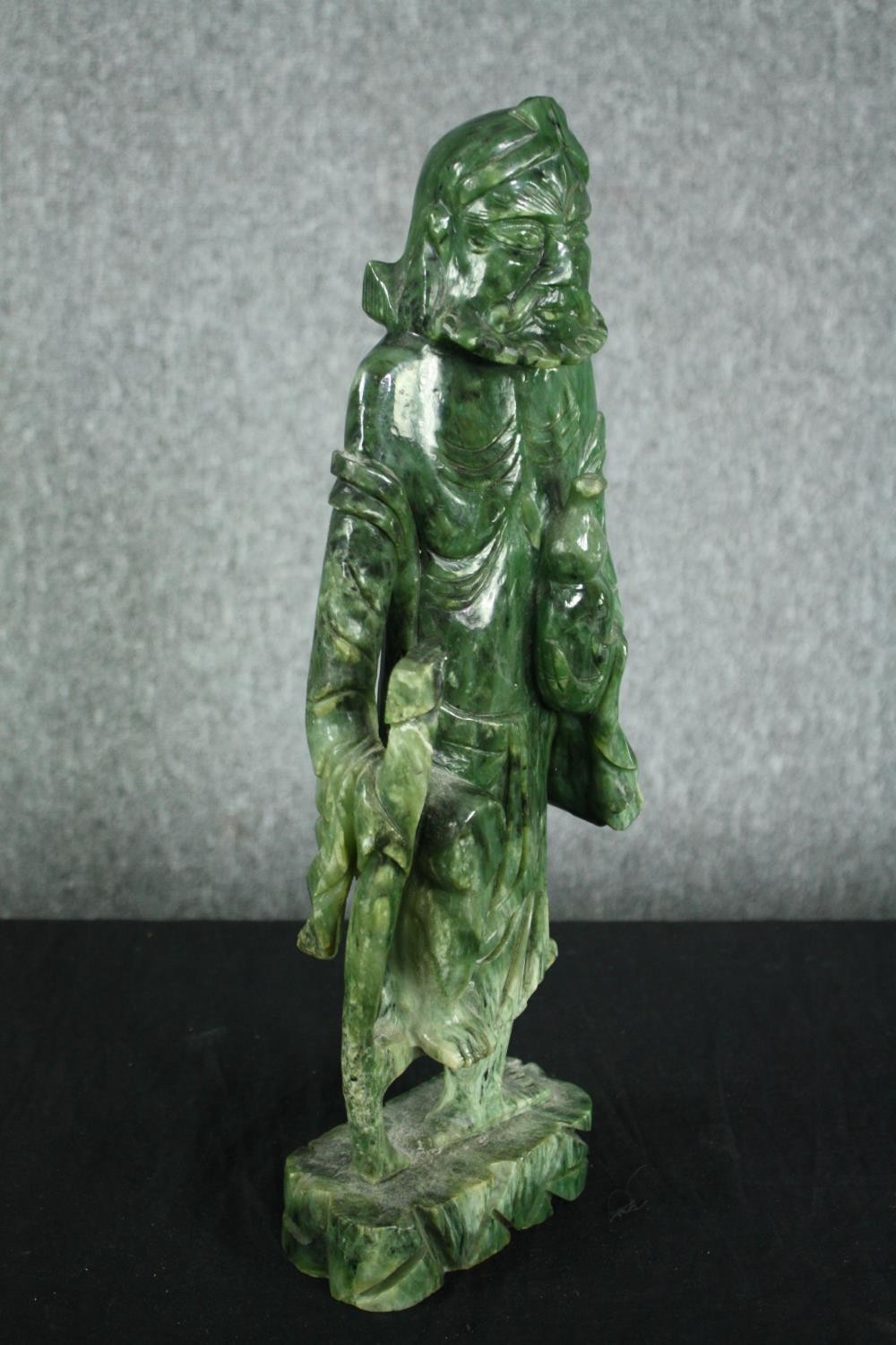 A 20th century carved spinach jade figure of a Chinese elder. H.43cm. - Image 2 of 5