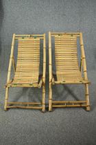 A pair of slatted bamboo deck chairs.