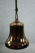 A modern decorative ceramic bell finished in a brass lustre. With a ceiling mount suspended by a