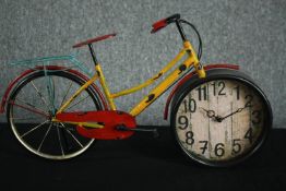 A clock in the form of a bicycle. In a distressed finish. H.33 W.55cm.