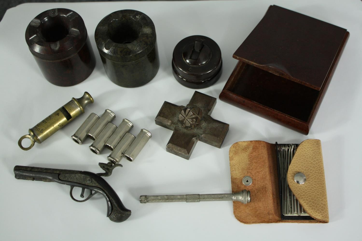 A miscellany. Includes a vintage pitch pipe tuner, brass whistle, a bakelite light switch, a