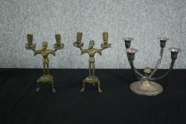 A pair of early 20th century medieval style brass bearded man candlesticks along with a silver