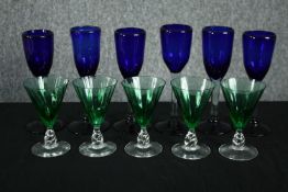 A set of six hand blown cobalt blue wine glasses with clear stems long with a set of five emerald