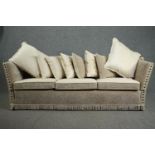 A Knole sofa, fully re-upholstered and covered with a matching set of cushions. H.80 W.250 D.75cm.