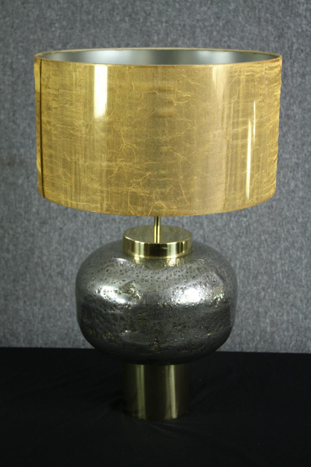 A modern designer table lamp. Brass and steel. With a distressed pitted finished and brass base. The