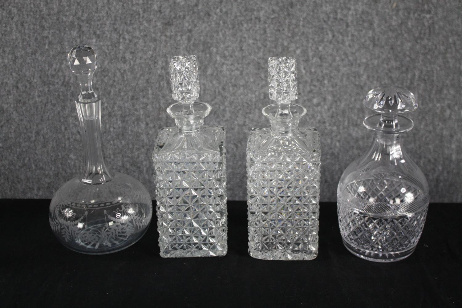 Four decanters with their stoppers. Cut glass with etched decoration. H.33cm. (largest) Proceeds