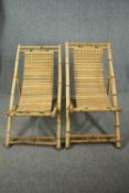 A pair of slatted bamboo deck chairs.