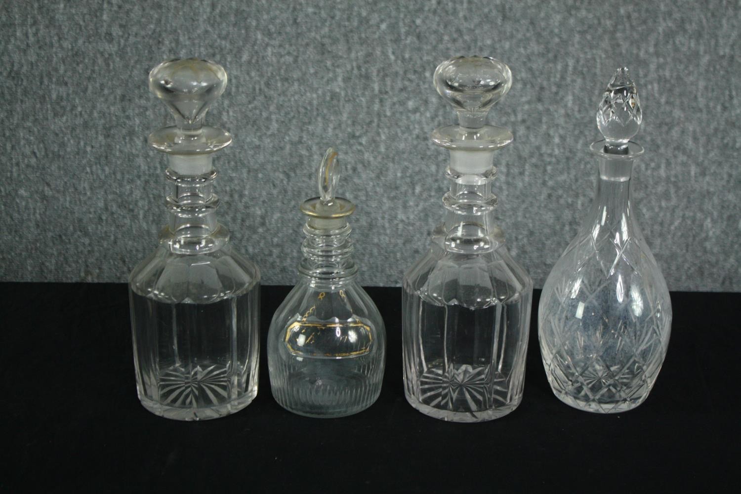 A collection of four early twentieth century cut glass decanters complete with their stoppers. One