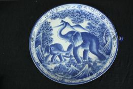 A 20th century blue and white elephant design plate. (has hole with handle attached). Dia.36cm.