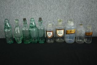 A collection of early 20th century apothecary jars and bottles, including five with name labels. H.