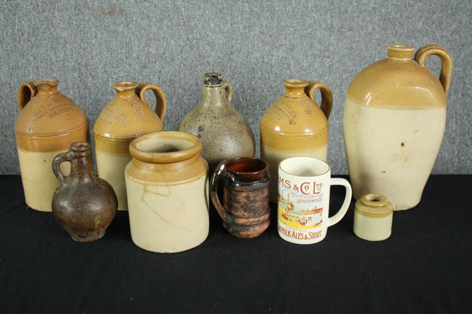 A collection of four 19th century stoneware honey glaze flagons with impressed maker's marks along