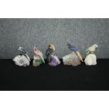 A collection of five pieces of amethyst mounted with detachable perched parrots carved from