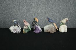A collection of five pieces of amethyst mounted with detachable perched parrots carved from