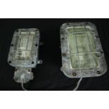 Two industrial cast metal anti flame corridor wall lights with opaque greenish glass. One smaller in