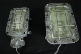Two industrial cast metal anti flame corridor wall lights with opaque greenish glass. One smaller in