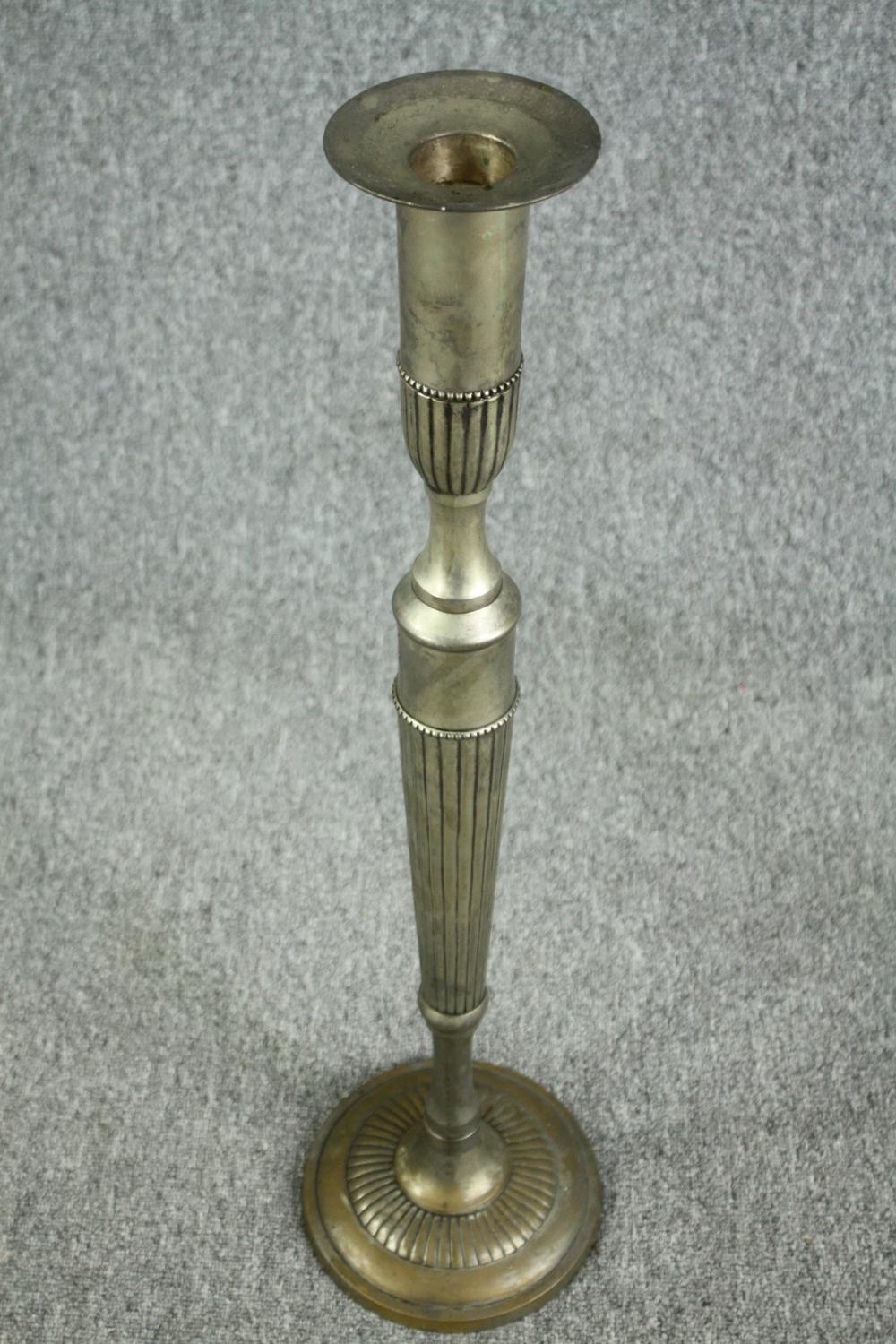 A pair of elongated silver plated brass candlesticks. In the neoclassical style. Circa 1930. H.80cm. - Image 2 of 4