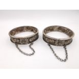 Two early 20th century repousse Chinese silver clip bangles, decorated with relief stylised