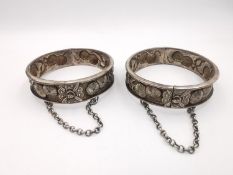 Two early 20th century repousse Chinese silver clip bangles, decorated with relief stylised