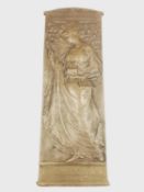 An Art Nouveau bronze relief plaque of a lady in flowing dress holding a magic lantern among blossom