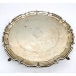 An Edwardian four footed silver tray by Barker Brothers. The tray has a scalloped ridged edge and