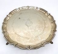 An Edwardian four footed silver tray by Barker Brothers. The tray has a scalloped ridged edge and