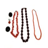 Two coral necklaces along with two carved jet brooches (one pin missing) and an earl;y cherry