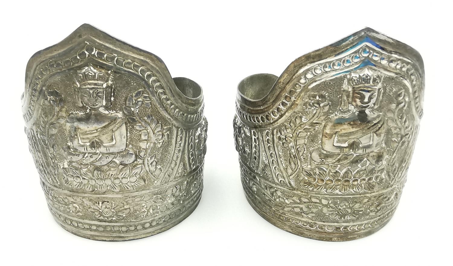 A pair of early 20th century repousse Chinese silver cuffs decorated with buddha and lotus motifs