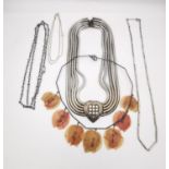 A collection of silver and white metal necklaces and chains, including a white metal snake chain and