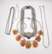 A collection of silver and white metal necklaces and chains, including a white metal snake chain and