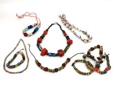 A collection of African jewellery, including African trade beads and a coral chunk and millefiori