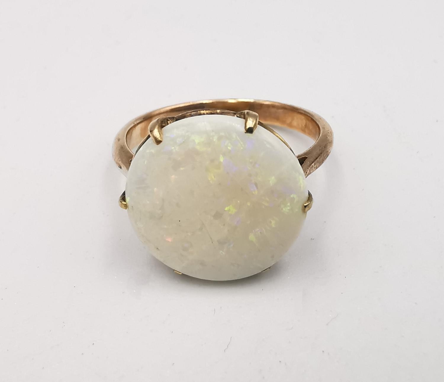An early 20th century pink metal (tests as 9ct) white opal dress ring, set with a round white opal