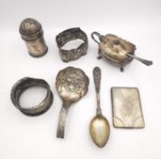 A collection of silver and white metal items, including a pepper shaker and salt, a Chinese hammered