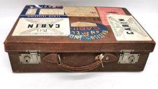 An early 20th century vintage tan lather suitcase with brass fittings. Decorated with vintage travel