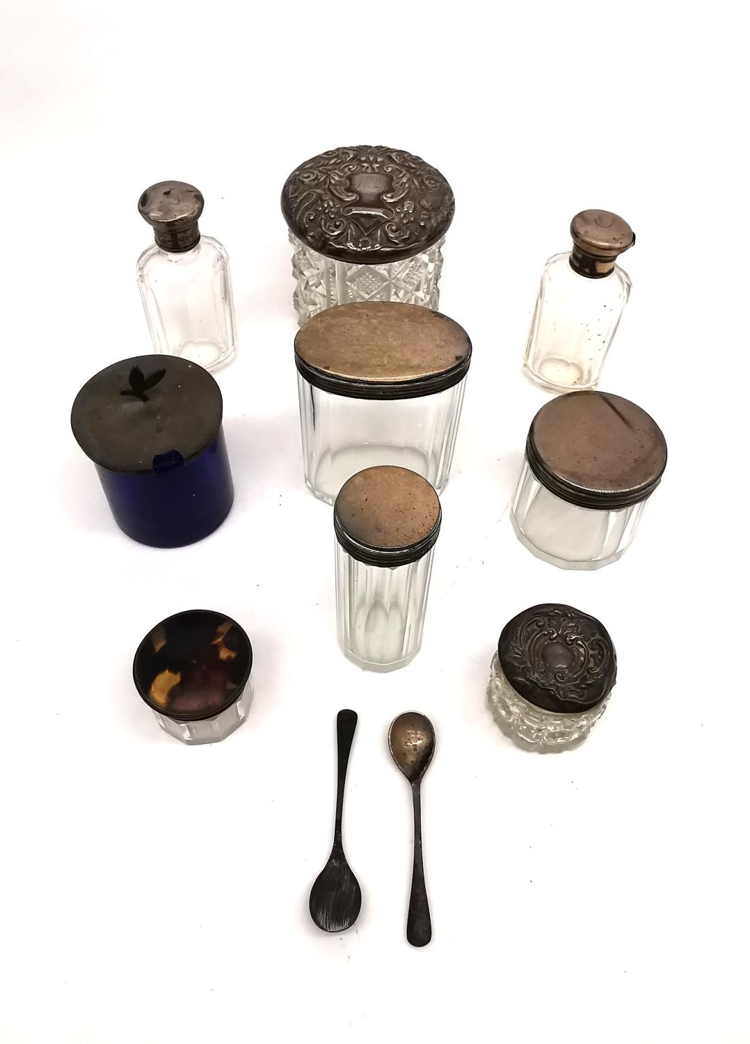A collection of nine silver topped glass dressing table jars and bottles with two silver salt