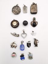 A collection of charms and silver pendants, including an Art Nouveau locket pendant, the front