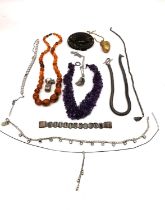 A collection of costume jewellery, including a statement buckle with brass filigree work, a gold