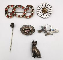 A collection of antique brooches, including a foil backed paste set red and white stone scrolling