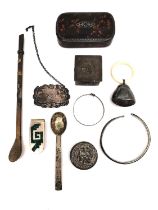 A collection of silver and white metal items, including a silver tea spoon, a silver baby bangle,