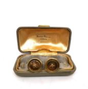 A boxed pair of 14 carat gold cufflinks in the form of buttons with gold wire for the stitch