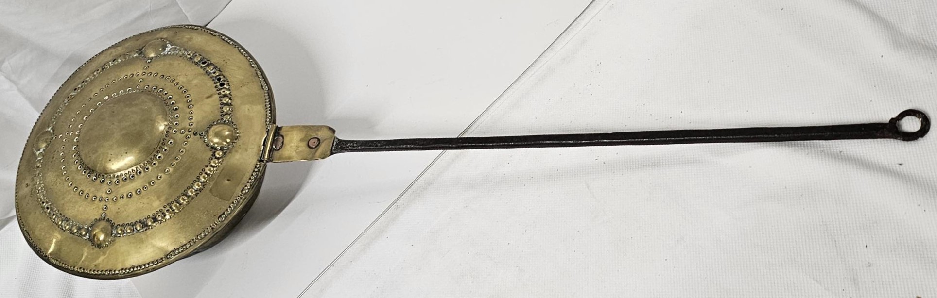 A 19th century brass chestnut roasting pan with boss detailing. L.100cm.